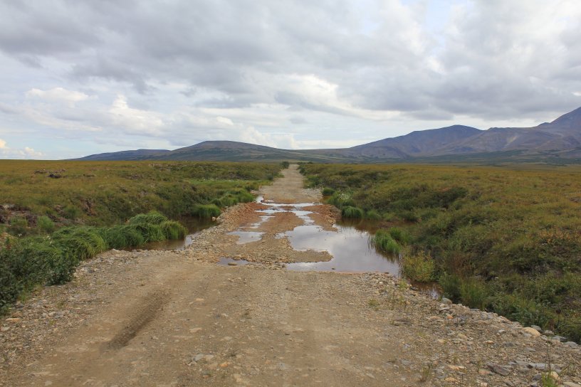 An example of thermo-karst topography caused by the melting of permafrost causing the road to drop. In this instance the relative elevation change is approximately 10 feet.